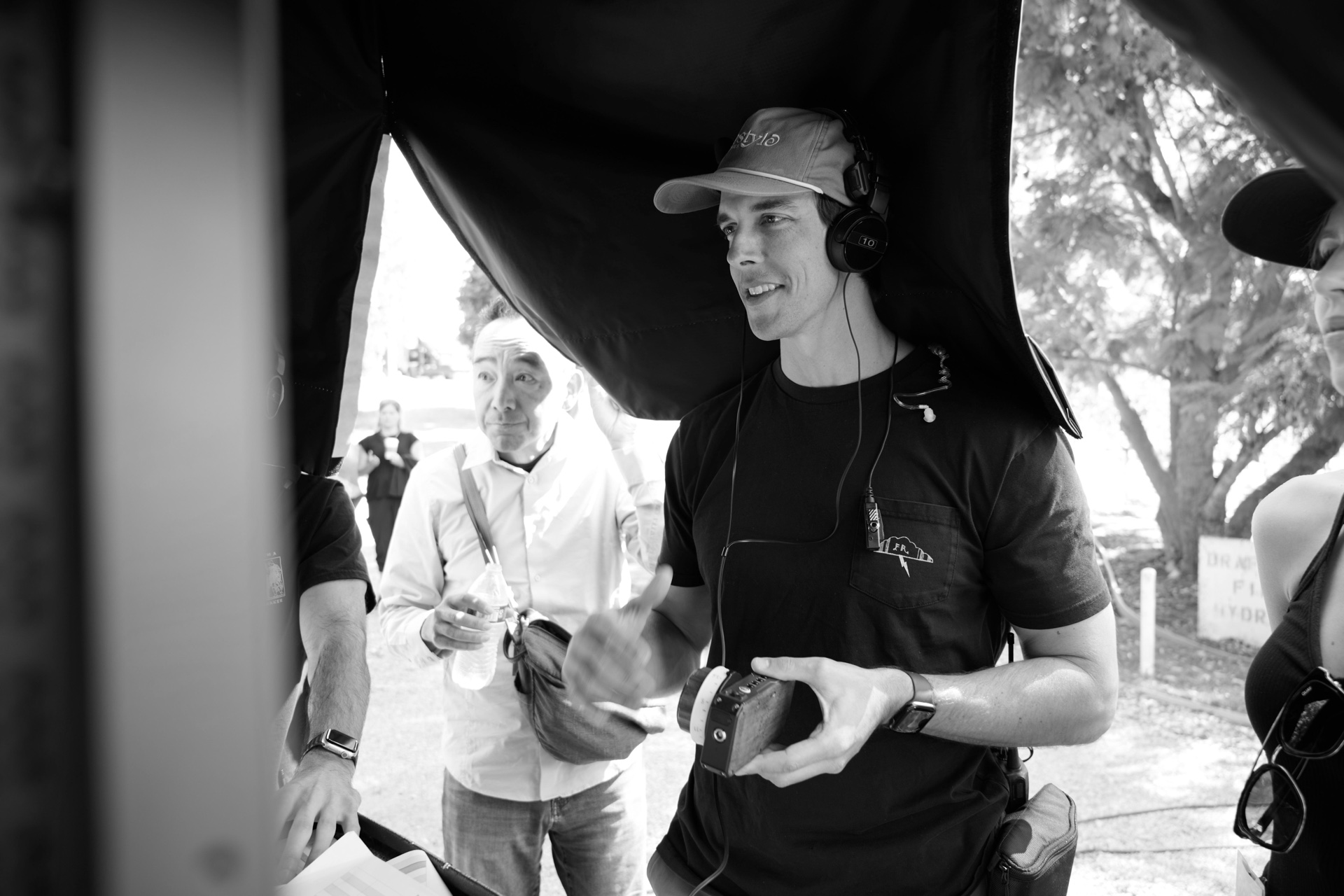 Taylor under a monitor tent with headphones and a wireless follow focus